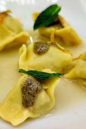 Ravioli del plin con genovese, cipolla bruciata, limone caramellato e menta